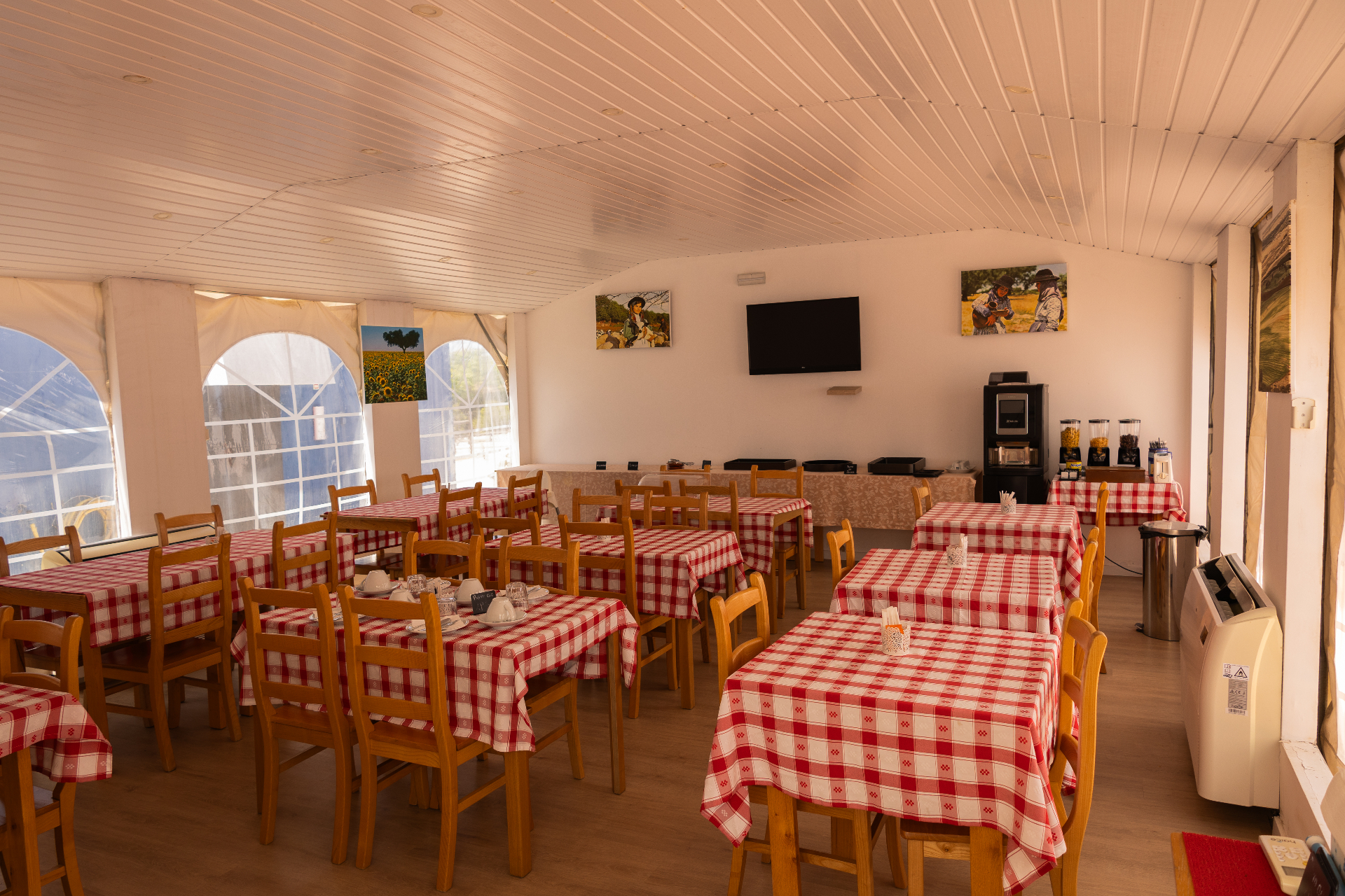 Sala de pequeno-almoço com mesas postas e vista para o jardim