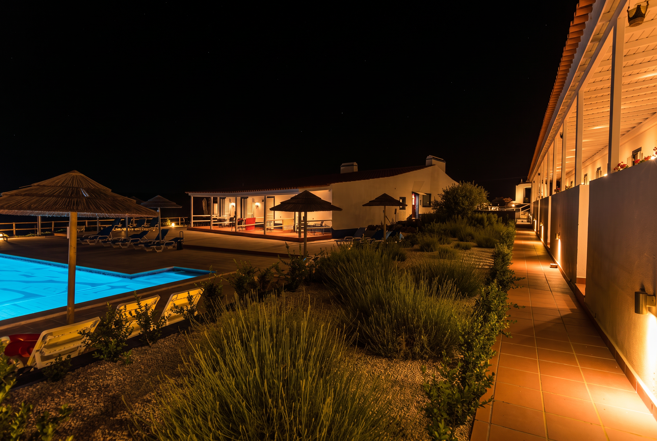 Piscina iluminada ao anoitecer com vista sobre o monte